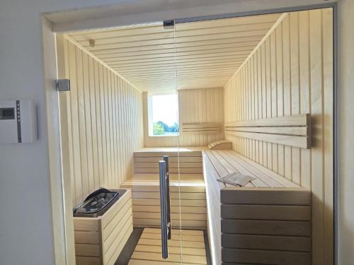 a small sauna with wooden floors and a window at Penthouse Strandoase in Norden