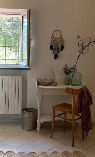 a table with a chair and a clock on the wall at B&B La Vera Vita in Troviggiano