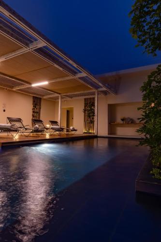 an empty swimming pool at night with chairs at Nueva Apartasuite de lujo in Santa Marta