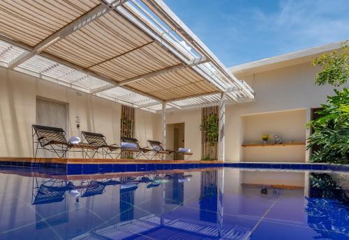 an indoor swimming pool with chairs and a ceiling at Nueva Apartasuite de lujo in Santa Marta