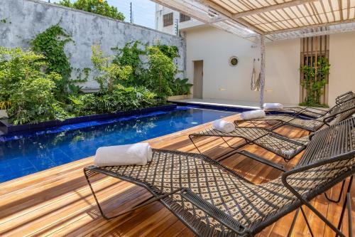 a patio with two chairs and a swimming pool at Nueva Apartasuite de lujo in Santa Marta