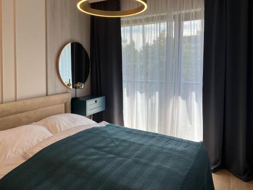 a bedroom with a bed and a large window at Apartament Morska Bryza Shellter Rogowo in Rogowo