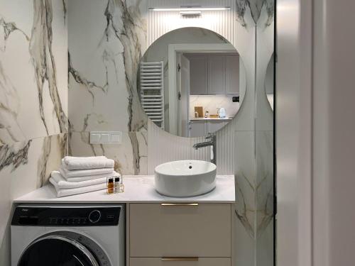 a bathroom with a sink and a washing machine at Apartament Morska Bryza Shellter Rogowo in Rogowo