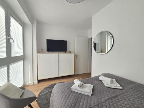 a bedroom with a bed and a mirror and a tv at Ferienappartment Hafenblick in Norden