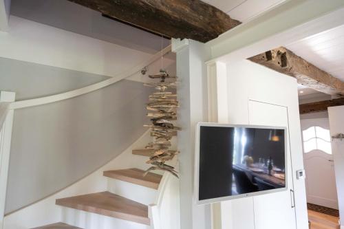una sala de estar con un televisor y una escalera con zapatos en Haus Frida, en Wyk auf Föhr