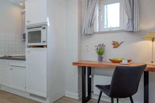 een keuken met een tafel en een magnetron bij Strand Loft in Westerland
