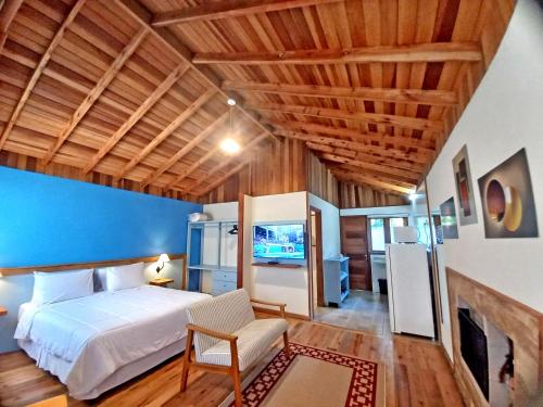 a bedroom with a white bed and a blue wall at Pousada Visconde de Mauá in Visconde De Maua