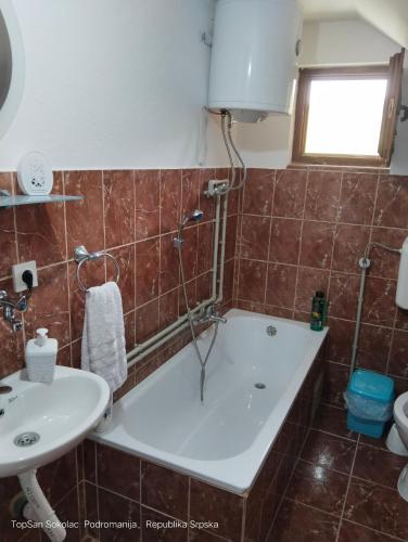 a bathroom with a tub and a sink at Topsan Prenociste Rooms in Sokolac