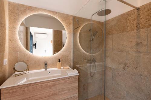 un bagno con lavandino e doccia in vetro di Bellezza - Villa climatisée piscine a Lecci