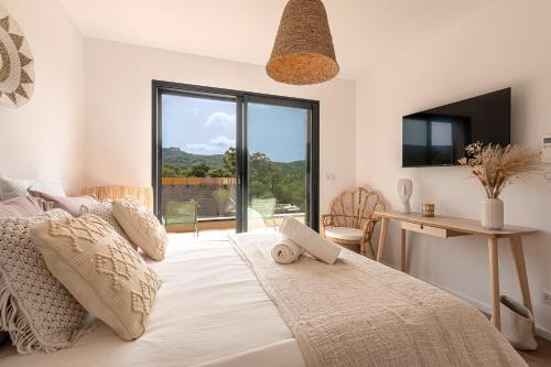 una camera con letto, scrivania e finestra di Bellezza - Villa climatisée piscine a Lecci