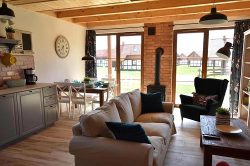 a living room with a couch and a table and a kitchen at Domek na Kaszubach 26-2 - Ostoja Bukowo in Borowy Młyn