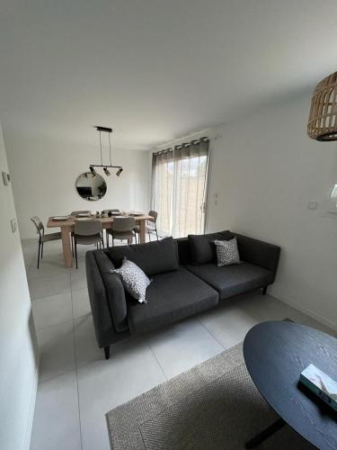 un salon avec un canapé et une table dans l'établissement Maison chaleureuse 1, à Saint-Genis-Laval