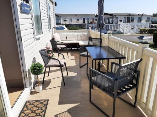a patio with chairs and a table on a balcony at Sandy Feet Retreat, West Sands in Selsey