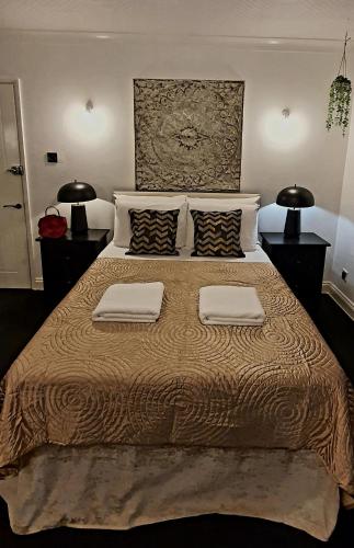 a bedroom with a large bed with two pillows at Rose Homestay Brighton - Free parking Ensuite studio room near Brighton Uni in Brighton & Hove