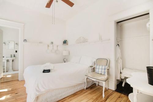 a white bedroom with a bed and a chair at Mayson Room BW Boutique Hotel in Central Lake