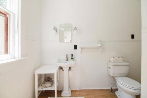 a white bathroom with a toilet and a sink at Mayson Room BW Boutique Hotel in Central Lake
