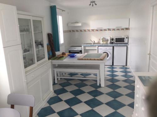 une cuisine avec une table au milieu dans l'établissement La Bonica , appartement 4 personnes, à Santʼ Andrea-di-Cotone