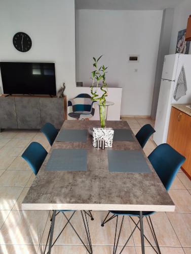 a dining table with blue chairs in a living room at Harmony Guest House in Pefkohori