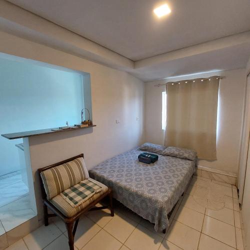 a bedroom with a bed and a chair and a screen at Pousada Serra Azul in Juquiá