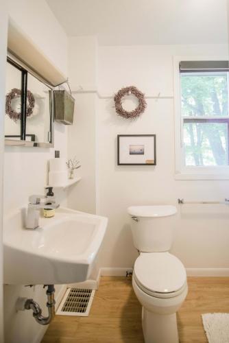 a white bathroom with a toilet and a sink at Amelia Room BW Boutique Hotel in Central Lake
