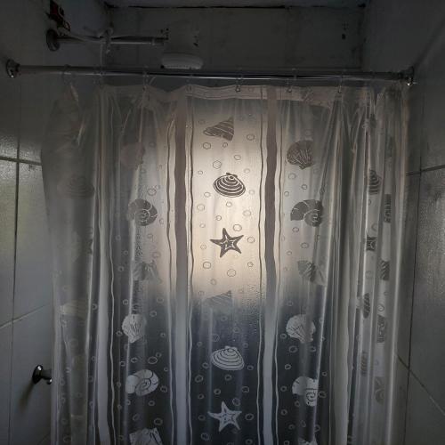 a shower curtain with fish on it in a bathroom at Pousada Serra Azul in Juquiá