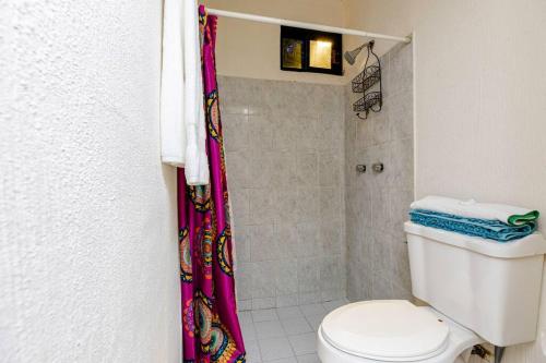 a bathroom with a shower curtain and a toilet at Casita Luna Sol in La Paz