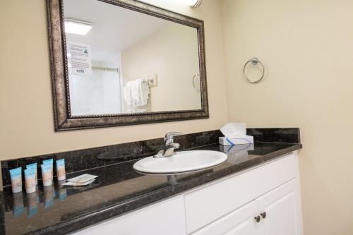 a bathroom with a sink and a mirror at Oceanfront Litchfield Inn in Pawleys Island