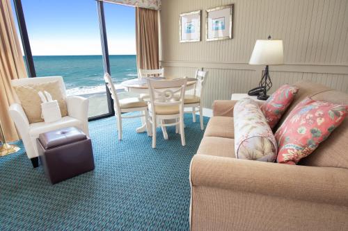 a living room with a couch and a table and chairs at Oceanfront Litchfield Inn in Pawleys Island