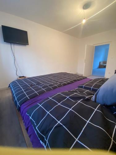 a bedroom with a bed and a tv on the wall at Ubytování U Jeníka Stráž nad Nežárkou in Jindrichuv Hradec