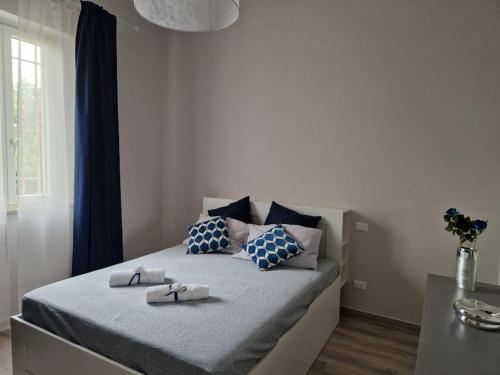a bedroom with a bed with blue and white pillows at La Casa del Borgo in Peccioli