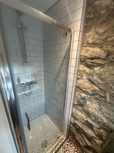 ein Badezimmer mit Dusche mit Glastür in der Unterkunft Cosy modern miners cottage in Llanllechid