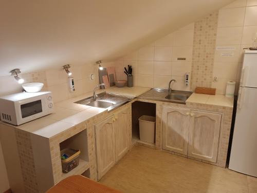 a small kitchen with a sink and a microwave at Aven'a pokoje gościnne z basenem in Darłowo