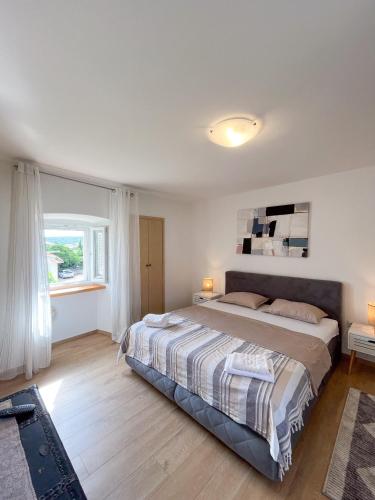a bedroom with a large bed and a window at Casa Placa in Kornić