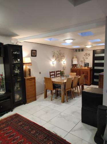 une cuisine et une salle à manger avec une table et des chaises dans l'établissement Idéal JO 2024, à Argenteuil