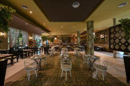 Un restaurante con mesas y sillas en una sala. en El Dorado Seaside Suites Oceanfront, Catamarán, Ecoturistic Ranch, All & More Inclusive - Adults Only, en Akumal