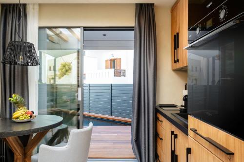 a kitchen with a table and a dining room at Legato Spa Suites With Private Pool in Naxos Chora