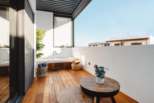 a bathroom with a tub and a table and a sink at Legato Spa Suites With Private Pool in Naxos Chora