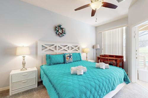1 dormitorio con 1 cama grande y colcha azul en Blue Sweet Haven, en Haines City