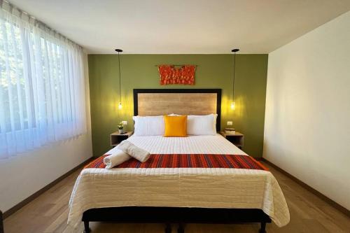 a bedroom with a large bed with yellow and orange pillows at Dk8 - Nice studio in Zona Viva in Guatemala