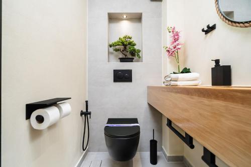 a bathroom with a black toilet and a sink at Legato Spa Suites With Private Pool in Naxos Chora