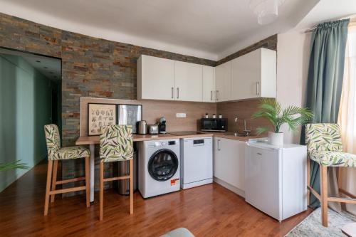 une cuisine avec des armoires blanches et une laveuse et une sécheuse dans l'établissement Le Gentilléen - Bel appartement à Gentilly pour 4, au Kremlin-Bicêtre