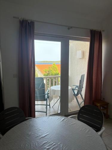 a room with a balcony with a table and chairs at Kuća Roza in Rukavac