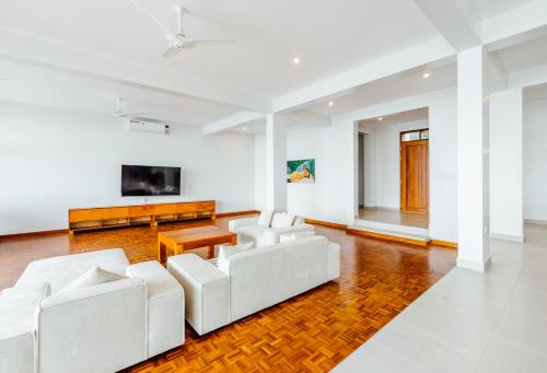 a living room with white furniture and a flat screen tv at YU Resort in Msambweni