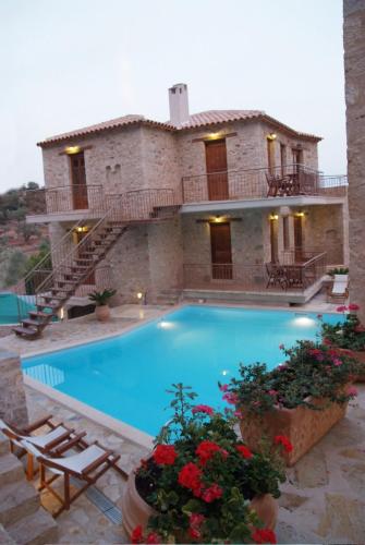a villa with a swimming pool in front of a house at Anigraia in Paralion astros