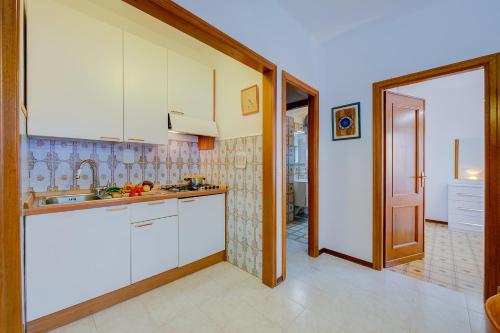kuchnia z białymi szafkami i zlewem w obiekcie Il Tulipano Giallo 100m From The Sea - Happy Rentals w mieście San Bartolomeo al Mare