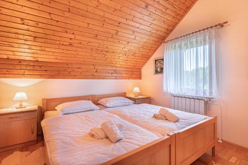 a bedroom with a large bed with a wooden ceiling at Family Friendly House Marija - Happy Rentals in Gradišča