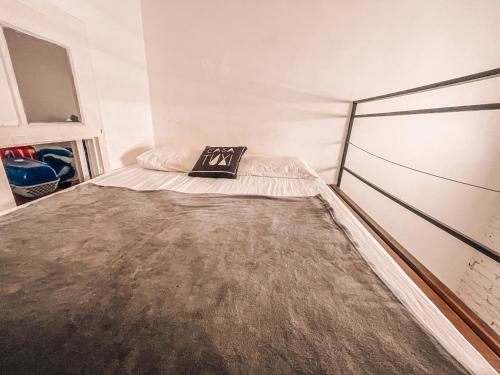 a small bedroom with a bed with a football jersey on it at Casa Tuxi in Rio de Janeiro