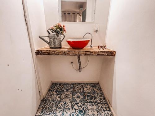 a bathroom with a counter with a bowl on a floor at Casa Tuxi in Rio de Janeiro