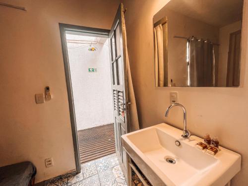 a bathroom with a sink and a mirror and a shower at Casa Tuxi in Rio de Janeiro