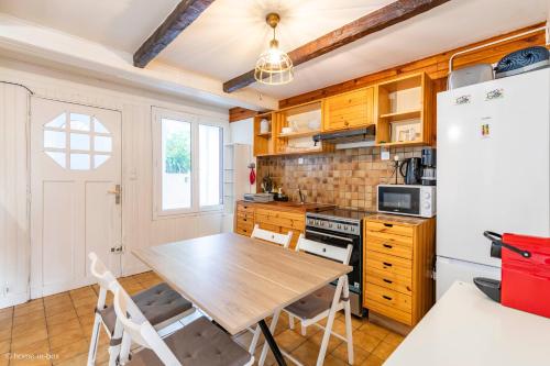 une cuisine avec une table en bois et un réfrigérateur dans l'établissement Maison 15 min Aeroport CDG -Parc Asterix - Chantilly, à Fosses
